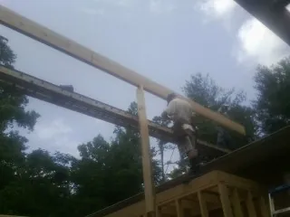Carpenter setting a ridge beam over a new addition frame — Ice Dam Removal by Roofing Brothers in New Wilmington