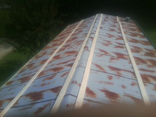 Rusted metal roof panels with new wood purlins before replacement — Storm Damage Roof Repair in New Wilmington by Roofing Brothers