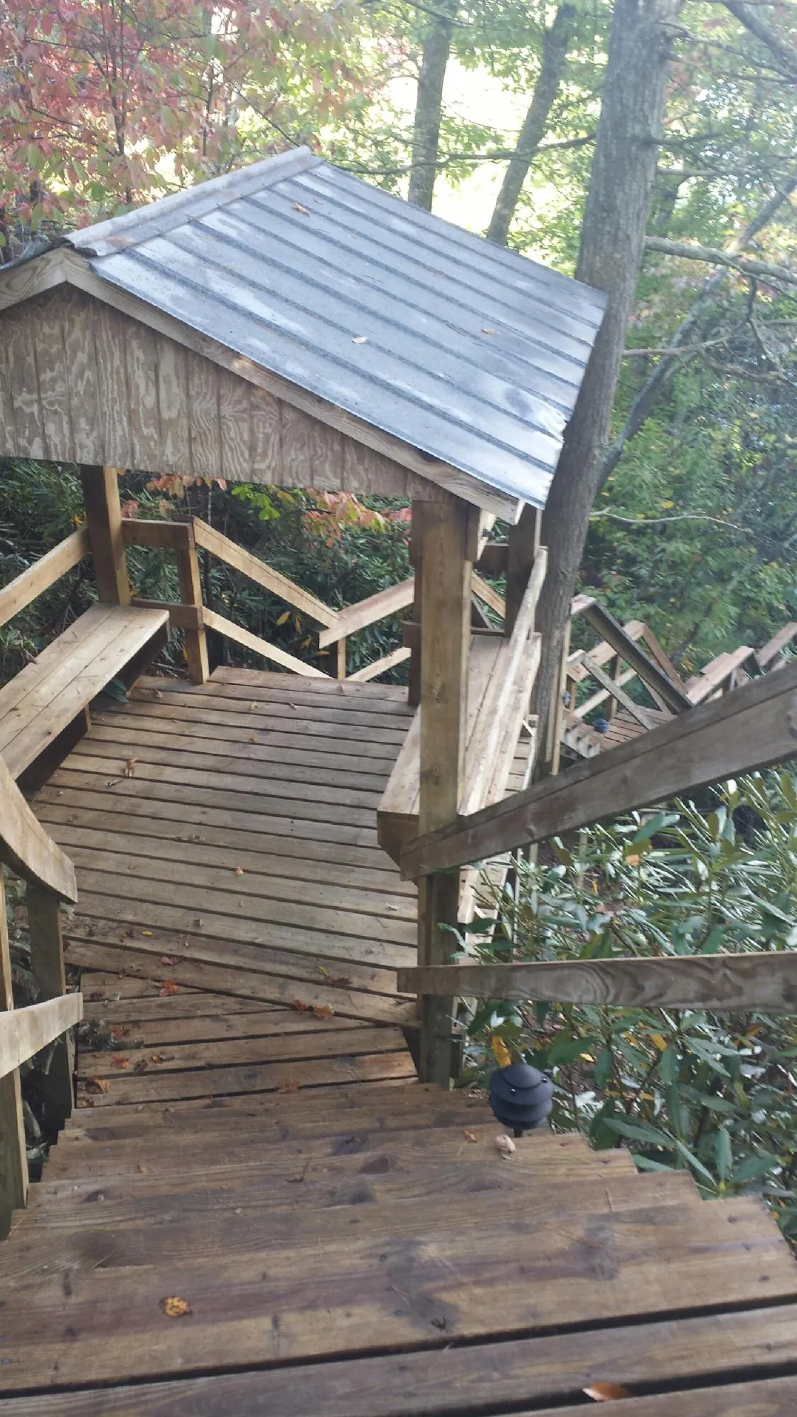 Metal roofed shelter over wooden steps on a wooded walkway — Skylight Repair & Installation work by our crew in New Wilmington