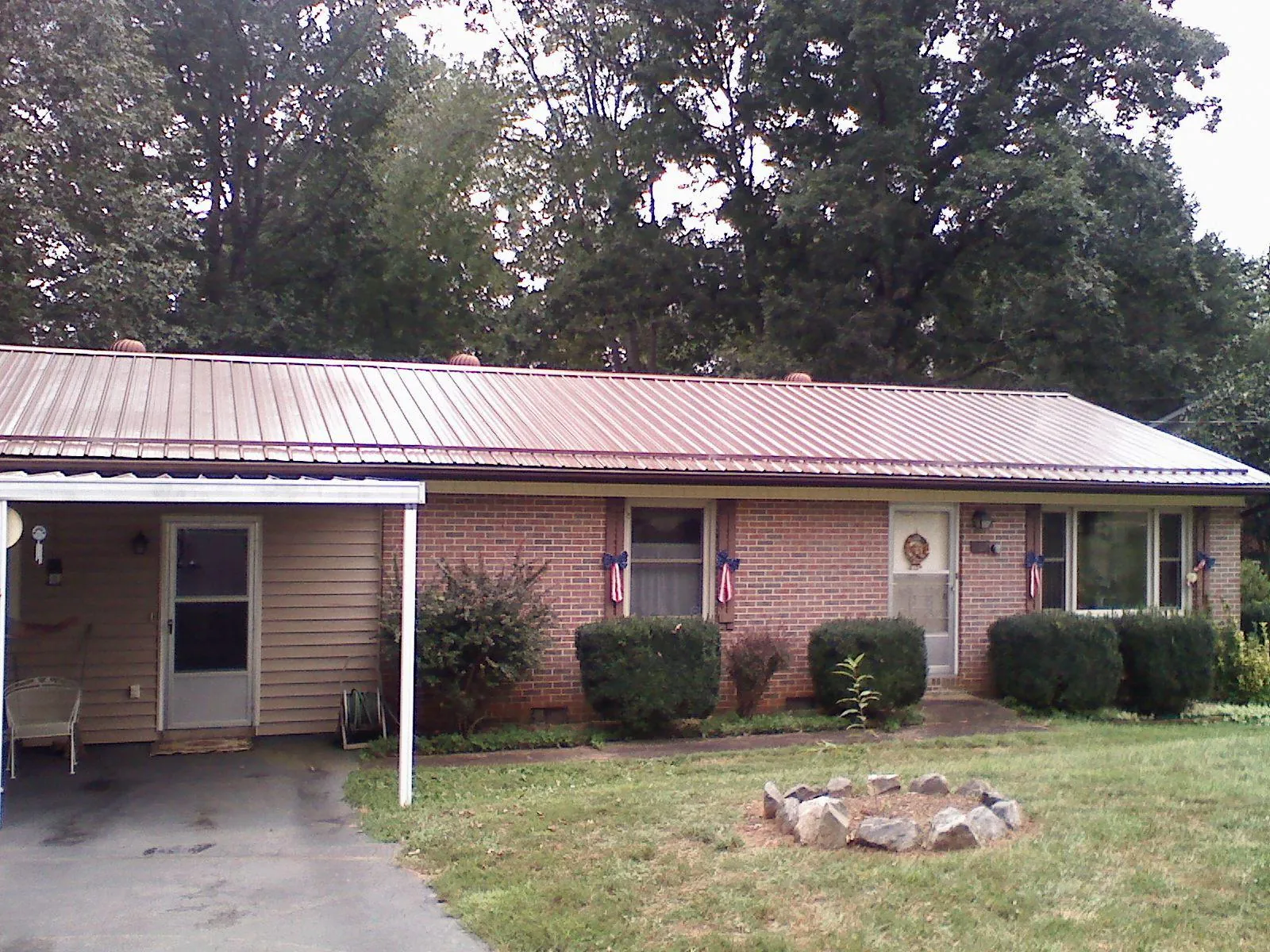 Bronze metal roof and carport on a brick ranch home — Roof Repair work by our crew in New Wilmington